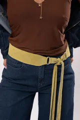 Faja de cuero gamuza color pistacho, con diseño curvado, herrajes plateados y cierre de nudo con flecos largos.