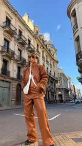 Pantalón de corte wide leg confeccionado en cuero sintético color marrón, con diseño de tiro medio y cierre frontal.