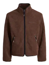 Campera de tejido tipo teddy color marrón, con cuello alto, cierre frontal completo y bolsillos laterales. Presenta un diseño de textura suave y abrigada con detalles de ribetes en color negro.