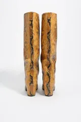 Bota alta de caña media con acabado en textura de piel de serpiente, diseño de puntera cuadrada y tacón bloque de altura media.