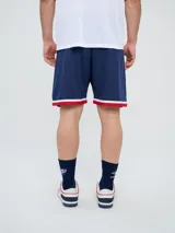 Short deportivo Umbro del Club Nacional de Football, modelo Match para hombre. Diseño en color azul marino con tejido de malla, detalles en blanco y rojo en los laterales y el escudo del club bordado.