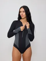 Malla entera de manga larga con cierre frontal, diseñada en combinación de colores negro y gris. Presenta un corte ajustado y moderno, ideal para actividades acuáticas.