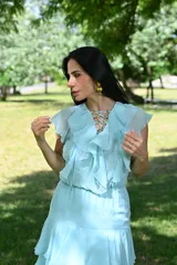 Vestido largo color beige con volados en el escote y falda escalonada.