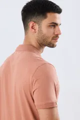 Remera polo de manga corta en color azul melange, con cuello camisero, cierre frontal de dos botones y pequeño bordado en el pecho.