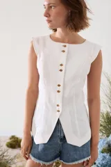 Chaleco de lino blanco con botones de madera frontales y costuras decorativas a contratono.