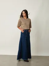 Pollera larga de denim azul con diseño de paneles, bolsillos delanteros y tajo frontal. Presenta terminación deshilachada en el ruedo.