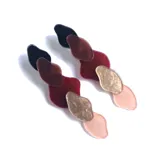 Par de aros colgantes con piezas abstractas de acrílico en color negro, marrón, rojo, dorado y rosa pálido.