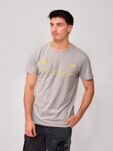 Remera gris de hombre con estampado amarillo en el frente con el logo de Rusty y la leyenda "Rusty Worldwide Supply Co. Since 1985". Corte regular y confeccionada en algodón.