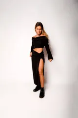 Pollera midi negra de corte recto con tajo lateral alto y cintura alta.