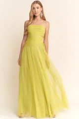 Vestido largo de fiesta color verde lima, confeccionado en tul con diseño de escote recto, breteles finos y detalles cut-out laterales en la cintura. Presenta un cuerpo drapeado y una falda amplia con caída fluida.
