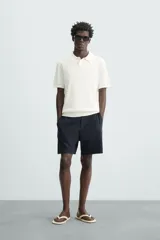 Polo de punto canalé color rosado, de corte regular fit, con cuello solapa y cierre frontal de botonadura. Manga corta y acabados en rib.