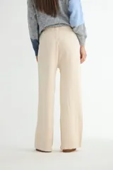 Pantalón tejido de corte recto y tiro alto, color beige, con cintura elástica ajustable mediante cordón y costura central vertical en cada pierna.
