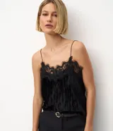 Blusa de terciopelo negro con breteles finos y escote decorado con encaje delicado. Presenta un corte fluido y elegante.