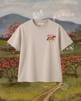 Remera de algodón color beige, de manga corta y cuello redondo, con pequeño estampado frontal de un caballo y la inscripción "Milonga" en color rosa.
