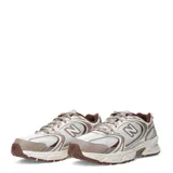 Championes New Balance 530, calzado de estilo retro running en tonos beige, marrón y blanco, con detalles metalizados, capellada de malla transpirable con superposiciones sintéticas, y suela con tecnología ABZORB.