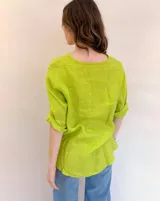 Blusa color verde lima de lino, con cuello en V, mangas 3/4 con dobladillo y cierre frontal con un botón de madera.