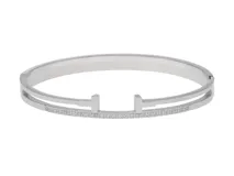 Esclava rígida de acero inoxidable con diseño abierto en el centro y detalle de circonias engastadas a lo largo de la estructura.