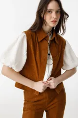 Chaleco marrón de gamuza con cuello camisero, botones escondidos y apliques tribales.