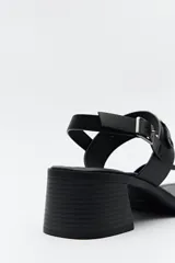 Sandalias de cuero color marrón con tacón cuadrado y hebilla lateral.