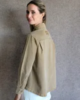 Sobrecamisa de denim azul con cuello camisero, cierre frontal con botones, mangas largas con puños abotonados y dos bolsillos con solapa en el pecho.