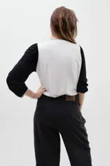 Remera de algodón con cuerpo blanco y estampado de flor de ginkgo en negro. Presenta mangas largas amplias de corte bombé en color negro con textura acanalada, y detalles de ribetes en gris melange en el cuello y los puños.