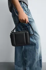 Bandolera negra acolchada con correa ajustable.