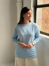 Sweater de punto color celeste con diseño de rombos en relieve en el frente, cuello redondo y mangas largas con puños ajustados.