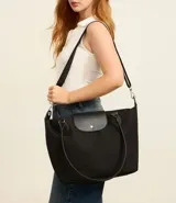 Bolso tipo shopper grande de poliéster color negro, con asas de hombro y solapa frontal con broche. Incluye correa transversal desmontable.