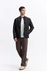 Campera de cuero sintético color negro, con cuello mao, cierre frontal y bolsillos laterales con cierre. Presenta detalles de costuras acolchadas en los hombros y un bolsillo pequeño con cierre en el pecho.