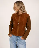 Campera de mujer combinada en lana merino y gamuza, color marrón. Presenta diseño tipo patch en el frente con paneles de gamuza con costuras visibles a contratono, cuello mao con cierre de botón a presión, mangas largas de punto acanalado y cierre frontal con cremallera.