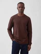 Remera de manga larga color marrón, con cuello redondo y puños acanalados.
