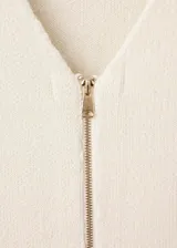 Chaqueta de punto de diseño entallado con cuello en pico y cierre frontal mediante cremallera. Presenta manga larga y un tejido de punto medio.