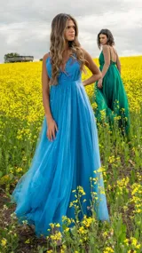 Vestido largo de fiesta color azul con breteles finos, escote en V y falda de tul con brillos.