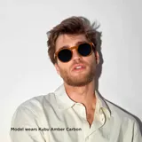 Lentes de sol unisex de forma redonda con armazón gris transparente de policarbonato y lentes polarizadas negras con protección UV400. Incluyen tratamiento antirayaduras y film superhidrofóbico.