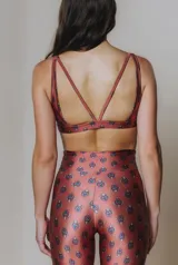 Top deportivo color ladrillo con estampado de cachemir en tonos azules. Tiene escote en U, breteles medios y tiras cruzadas en la espalda.