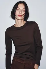 Camiseta de manga larga confeccionada en tejido de punto interlock elástico y flexible, con cuello redondo y bajo recto.