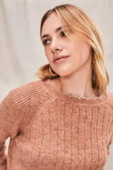 Sweater de punto color salmón con cuello redondo y mangas raglán.
