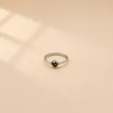 Anillo minimalista de plata 925 con diseño de banda fina y una pequeña piedra engastada en el centro.