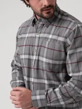 Camisa de franela a cuadros de algodón orgánico color gris, con dos bolsillos frontales, cierre de botones y cuello camisero.