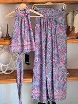 Conjunto de dos piezas color fucsia con estampado oriental en tonos rosa y blanco, compuesto por un top halter con lazo en la cintura y un pantalón palazzo de cintura alta con elástico.