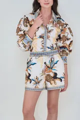 Short de popelina de algodón blanco, con cintura elástica y cordón ajustable. Presenta un estampado de inspiración tropical con tigres y palmeras en tonos marrones y azules.