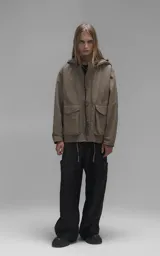Campera técnica liviana color beige, confeccionada en microfibra de alta densidad con acabado mate. Presenta mangas desmontables que permiten convertirla en chaleco, cuello tipo camisa, cierre frontal oculto bajo cartera y logo bordado en el pecho. Incluye cuatro bolsillos frontales de gran tamaño con solapa y puños con elástico.