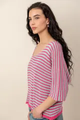 Sweater de tejido de punto a rayas horizontales en tonos beige y blanco, con escote en V y mangas cortas holgadas.