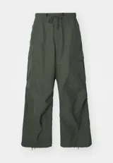 Pantalón cargo verde militar de corte ancho, con cintura elástica ajustable con cordón y múltiples bolsillos con solapa.