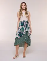 Vestido midi combinado de corte fluido. Presenta un torso ajustado acanalado sin mangas, con cuello redondo y sisas clásicas. Cuenta con cintura elastizada con lazo para anudar y falda evasé con estampado floral y geométrico, finalizando con un volante en el ruedo.