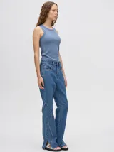 Pantalón de jean tiro alto con corte ochentoso y terminación oxford. Presenta apliques metálicos decorativos alrededor de los bolsillos delanteros y traseros, y a lo largo de la parte externa de las piernas.