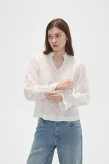 Blusa de viscosa color bordó con diseño bordado geométrico, cuello en V y mangas largas con terminación en volados.