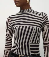 Blusa de manga larga ajustada al cuerpo, confeccionada en tejido de tule con cuello alto y diseño de estampa geométrica abstracta en tonos blanco y negro.