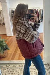 Campera de diseño combinado con cuello alto y cierre frontal. La parte superior presenta un estampado a cuadros en tonos beige y marrón, mientras que la parte inferior es de color verde oliva con un diseño acolchado en forma de rombos.