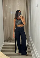 Top corto tejido a mano, color negro y beige, con tirantes finos y diseño de costura en zigzag.